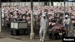 Para pekerja membawa daging asin yang akan diolesi, dikeringkan dan kemudian dikemas di pabrik JBS S.A, produsen daging sapi terbesar dunia, di Santana de Parnaiba, Brazil. (Foto: REUTERS/Paulo Whitaker)