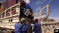 Southern Sudanese people in the north load their belongings on the truck as they prepare to leave for the south before the secession referendum, in an area called Mandela in Khartoum January 5, 2011