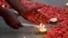 Penyalaan lilin di sekitar pita merah, simbol kesadaran dan dukungan universal bagi mereka yang hidup dengan HIV, pada peringatan Hari AIDS Sedunia di Kolkata, India, Rabu, 1 Desember 2021. (AP Photo/Bikas Das)