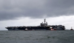 FILE- The U.S. aircraft carrier USS Ronald Reagan is seen anchored off Manila Bay, Philippines, Aug. 7, 2019, for a port call after sailing through the disputed South China Sea amid new territorial flare-ups involving China and rival claimant states.