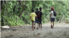 Varios jóvenes caminan en la selva del Darién en Panamá, no lejos de la ciudad portuaria colombiana de Capurganá, el 25 de junio de 2021. (David Hernández para VOA)