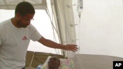 Nigerian-born Dr. Chibuzo Okonta with Doctors Without Borders attends to a patient in Port-au-Prince