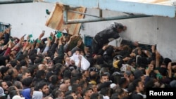 Palestinci primaju pomoć ispred skladišta UNRWA-e u gradu Gazi