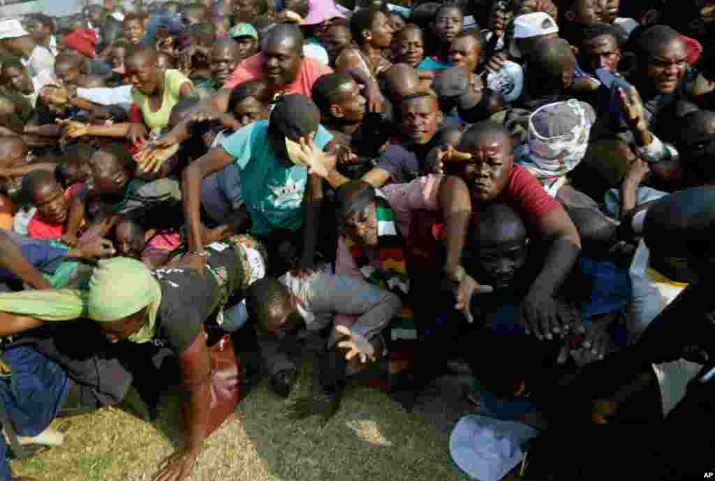 Mourners stampede after the arrival of the coffin carrying former President Robert Mugabe at the Rufaro Stadium in Harare, where Mugabe will lie in state for a public viewing.