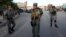 FILE - Afghan security forces stand guard at site of suicide car bombing attack in Kabul, May 19, 2015.