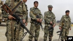 Afghan forces stand guard during a security transition ceremony from private security companies to the Afghan government in Kabul, March 15, 2012. 