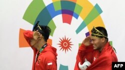 Atlet pencak silat Indonesia, Hendy (kiri) dan Yola Primadona Jampil, menangis saat lagu Indonesia Raya berkumandang, setelah memenangkan nomor seni berpasangan putra, di Asian Games, 27 Agustus 2018. 