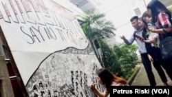 Beberapa mahasiswa memperhatikan aksi Valencia yang melukis doodle art dengan tema ajakan tidak golput pada Pemilu 2019 (foto: VOA/Petrus Riski)