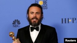 FILE - Casey Affleck holds the award for Best Performance by an Actor in a Motion Picture - Drama for his role in "Manchester by the Sea" during the Golden Globe Awards in Beverly Hills, California, Jan. 8, 2017.
