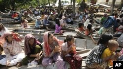 Local villagers wait on boats to receive flood donations at Prek Sussey, Kandal province, some 50 kilometers (31 miles) east of Phnom Penh, Cambodia, Tuesday, Oct. 18, 2011. More than a thousand families in a part of Kandal province Tuesday have received 