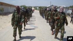 Members of Somalia's al- Shabab militant group patrol on foot on the outskirts of Mogadishu, March 5, 2012.