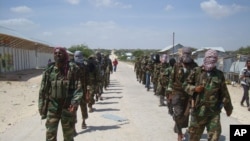 Members of Somalia's al- Shabab militant group patrol on foot on the outskirts of Mogadishu, March 5, 2012.