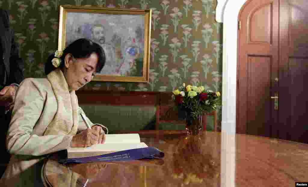 Aung San Suu Kyi menandatangani sebuah buku di Institut Nobel setelah bertemu dengan Komite Nobel Norwegia di Oslo, Sabtu (16/6).
