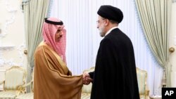 FILE - Saudi Arabian Foreign Minister Prince Faisal bin Farhan shakes hands with Iranian President Ebrahim Raisi in Tehran on June 17, 2023. Iran removed visa requirements for Saudi visitors, among others, on Dec. 14. (Office of the Iranian Presidency via AP)