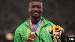 Le Burkinabé Hugues Fabrice Zango, médaillé de bronze, pose avec sa médaille sur le podium après l'épreuve du triple saut hommes lors des Jeux Olympiques de Tokyo 2020 au stade olympique de Tokyo le 5 août 2021.