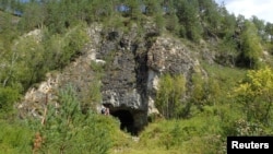 The entrance to Denisova Cave, which contains evidence of previous habitation by extinct human species, in the Anui River valley in the Altai mountains of Siberia, Russia, is shown in this image released on Jan. 30, 2019. 