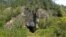 The entrance to Denisova Cave, which contains evidence of previous habitation by extinct human species, in the Anui River valley in the Altai mountains of Siberia, Russia, is shown in this image released on Jan. 30, 2019. 