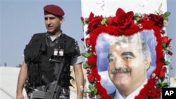 A Lebanese police stands guard near a decorated picture of slain former Prime Minister Rafiq Hariri during a rally in Beirut's Martyrs' Square, Lebanon, 14 Feb 2010.