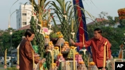 Cambodian Prime Minister Hun Sen, right, sprays perfume together with Deputy Prime Minister Sok An during a ground breaking ceremony for the site where a statue of Cambodia's late King Norodom Sihanouk will be built, in front of Independence Monument in Phnom Penh, Cambodia, February 20, 2013.