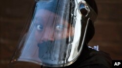 FILE — In this Aug. 24, 2020 file photo, a student, wearing a face mask and shield, returns to the Melpark Primary School in Johannesburg after several months of lockdown.