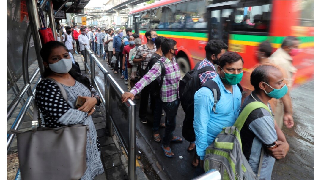 Orang-orang yang memakai masker do tengah pandemi COVID-19, menunggu di halte bus di Mumbai, India, Senin, 7 Juni 2021.