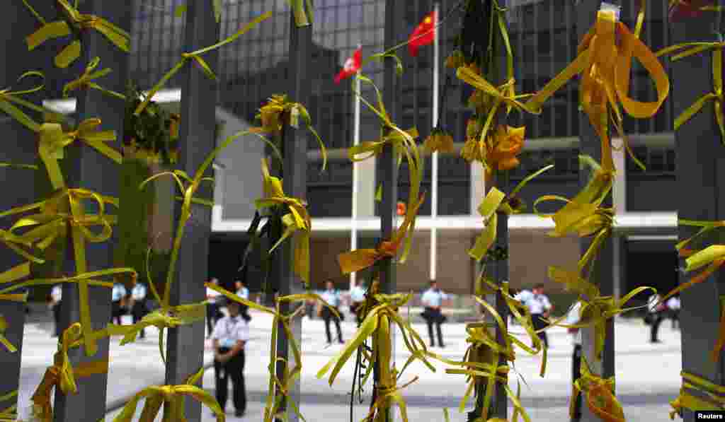 Police officers, seen behind yellow ribbons representing "universal suffrage", guard the entrance of the government headquarters building as protesters block the surrounding streets in Hong Kong, Oct. 2, 2014.