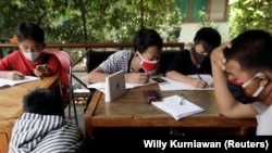 Dimas Anwar Saputra, seorang siswa SMP, bersama teman-temannya memanfaatkan jaringan internet gratis di kantor kelurahan untuk belajar di tengah pandemi COVID-19, di Jakarta, 9 September 2020. (Foto: Willy Kurniawan/Reuters)