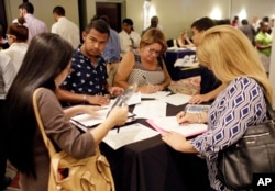 미국 플로리다주 마이애미레이크에서 열린 취업박람회에서 참가자들이 지원서를 작성하고 있다.