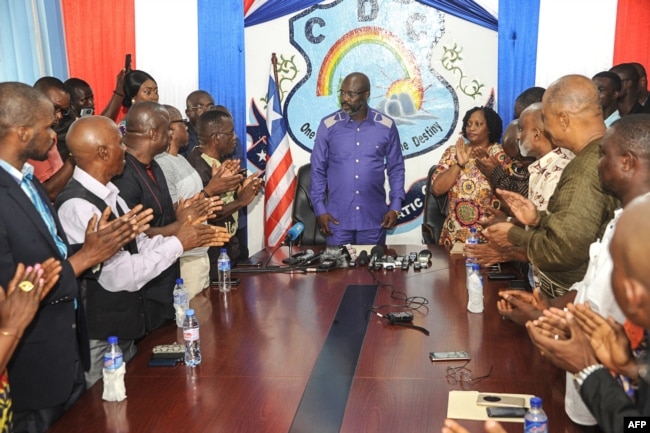 Former international soccer star George Weah is applauded as he arrives to speak to the press in the Liberian capital, Monrovia, on Dec, 30, 2017, the day after Liberia's elections board officially certified Weah as the winner of the nation's presidential election.