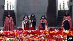 Armenian Apostolic Church leader Catholicos Garegin II, second left, and other clerics attend a service at the monument to victims of killings by Ottoman Turks, to commemorate the 105th anniversary of the massacre in Yerevan, Armenia, April 24, 2020.