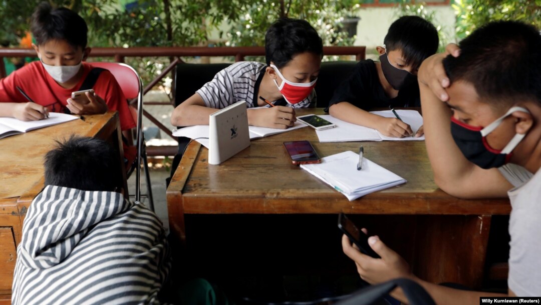 Sejumlah pelajar SMP memanfaatkan jaringan internet gratis di kantor kelurahan untuk belajar di tengah pandemi COVID-19, di Jakarta, 9 September 2020. (Foto: Willy Kurniawan/Reuters)