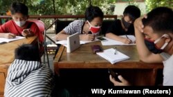 Sejumlah pelajar SMP memanfaatkan jaringan internet gratis di kantor kelurahan untuk belajar di tengah pandemi COVID-19, di Jakarta, 9 September 2020. (Foto: Willy Kurniawan/Reuters)