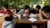 Dimas Anwar Saputra, seorang siswa SMP, bersama teman-temannya memanfaatkan jaringan internet gratis di kantor kelurahan untuk belajar di tengah pandemi COVID-19, di Jakarta, 9 September 2020. (Foto: Willy Kurniawan/Reuters)