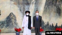 FILE - Chinese Foreign Minister Wang Yi meets with Mullah Abdul Ghani Baradar, political chief of Afghanistan's Taliban, in Tianjin, China, July 28, 2021.