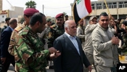 El primer ministro iraquí, Haider al-Abadi, camina por las calles de Tikrit tras recuperar la ciudad.