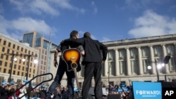 President Barack Obama stands with singer Bruce Springsteen as he arrives to speak at a campaign event in Madison, Wisconsin, Nov. 5, 2012.