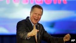 Republican presidential candidate Ohio Gov. John Kasich pumps his fist and celebrates before speaking at his presidential primary election rally in Berea, Ohio, March 15, 2016. 