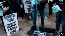 AIDS activists pour cat litter on an image of Turing Pharmaceuticals CEO Martin Shkreli in a makeshift cat litter pan during a protest highlighting pharmaceutical drug pricing, in front of the building that houses Turing's offices, in New York.