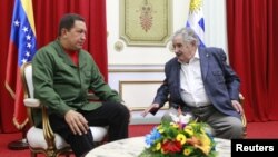 El presidente venezolano, Hugo Chávez da la bienvenida al presidente de Uruguay, José Mujica en el Palacio de Miraflores en Caracas 07 de abril 2010.