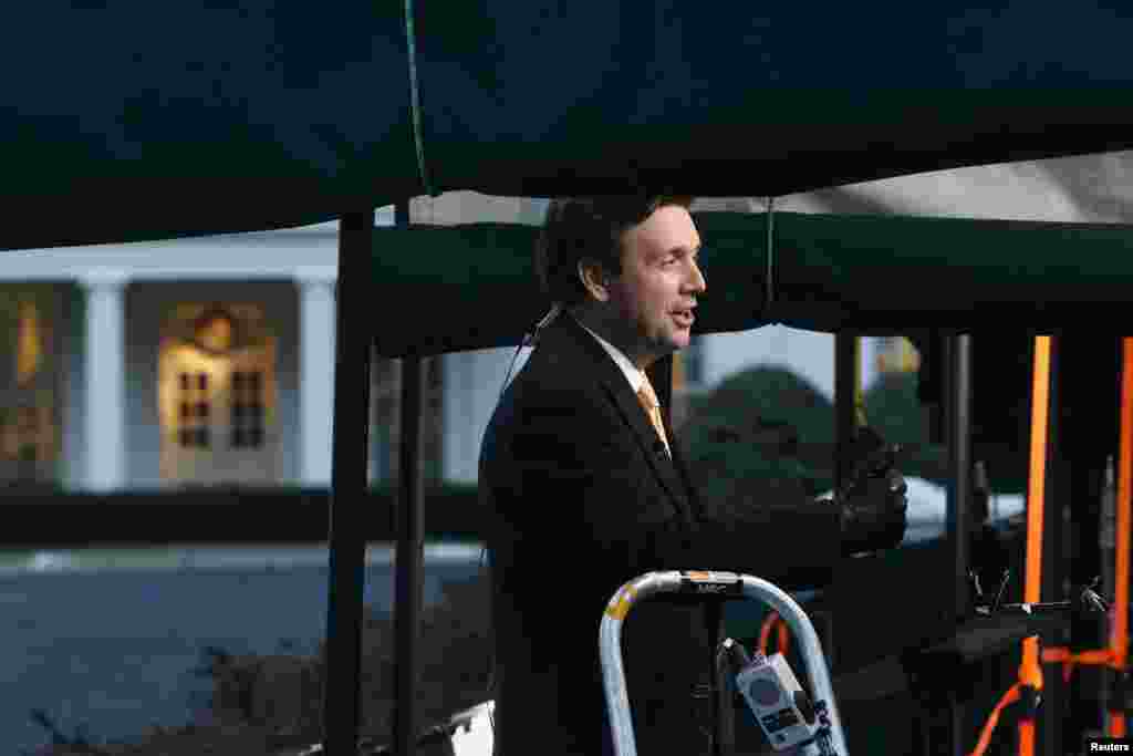 White House spokesman Josh Earnest gives a remote network television interview about the upcoming State of the Union address outside the West Wing of the White House, Jan. 20, 2015.