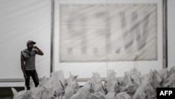 FILE - A worker stands by bags of rice stored under a tent of the World Food Program (WFP) in Deurali village of Nepal's Gorkha district, May 6, 2015.