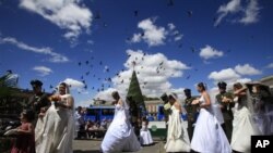 Couples walk together before getting married at a collective Catholic wedding for 97 police officers and their fiancees at the Cathedral in Bogota, Colombia, Friday Dec. 9, 2011. Every year before Christmas the police organize a mass wedding for officers.