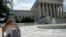 A woman uses her mobile phone at the plaza of the U.S. Supreme Court, Washington, June 25, 2014.