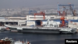 Kapal induk Tiongkok 'Liaoning' bersandar di pelabuhan Dalian, timur laut propinsi Liaoning, Tiongkok (Foto: dok). Angkatan Laut Tiongkok berhasil mendaratkan pesawat jet tempur untuk pertama kalinya dalam latihan pendaratan, Minggu (25/11).