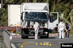 Investigators continue to work at the scene near the heavy truck that ran into a crowd at high speed, killing scores who were celebrating the Bastille Day on the Promenade des Anglais in Nice, France, July 15, 2016.