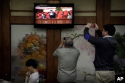 FILE - Restaurant diners watch a broadcast of the seventh congress of the Workers' Party of Korea on local television, where North Korean leader Kim Jong Un is seen delivering a speech, in Pyongyang, May 6, 2016.