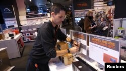 Worker Ino Andre Nilsen arranges digital radios in an Expert City electronics shop in Oslo, Norway, Jan. 4, 2017.