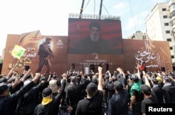 Pemimpin Hizbullah Lebanon Sayyed Hassan Nasrallah muncul di layar saat ia berpidato di hadapan para pendukungnya selama prosesi keagamaan untuk memperingati Ashura di pinggiran selatan Beirut, Lebanon, 17 Juli 2024. (Foto: REUTERS/Aziz Taher)