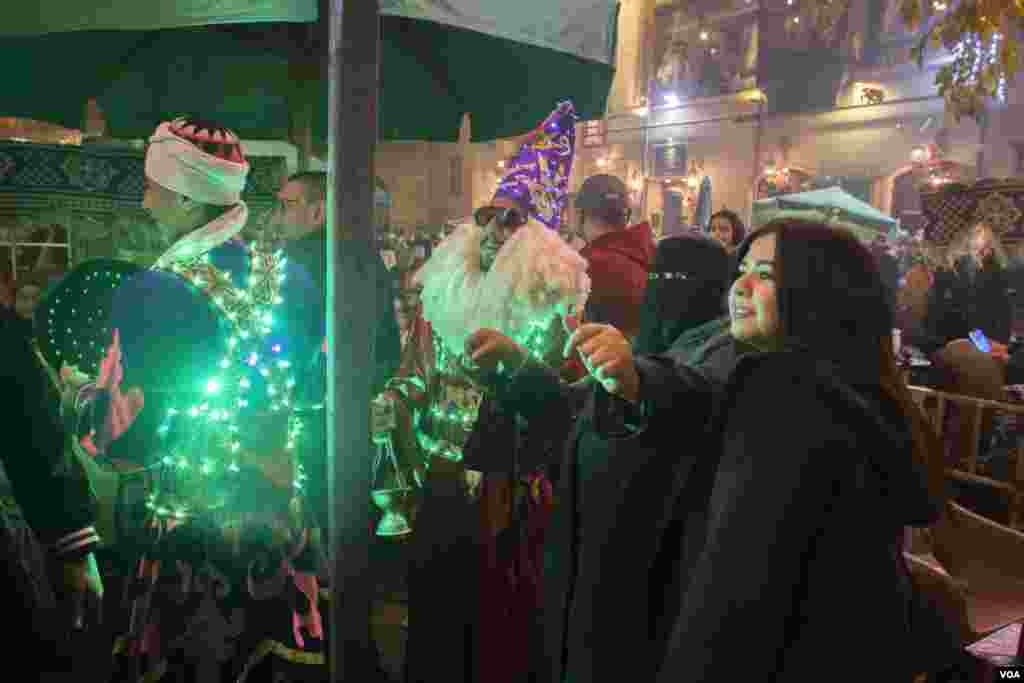 Women dance with a man in a Santa Claus costume during a Christmas-themed performance in a historic neighborhood of Islamic Cairo, Dec. 31, 2021. (H. Elrasam/VOA) 