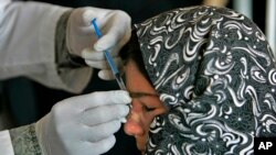 An Afghan woman affected by leishmaniasis gets an injection at a free specialized clinic for supported by World Health Organization in Islam Qala, Herat, Afghanistan, Oct. 30, 2010.